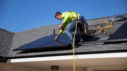 Techniker verschraubt die Unterkonstruktion einer Solaranlage auf dem Dach